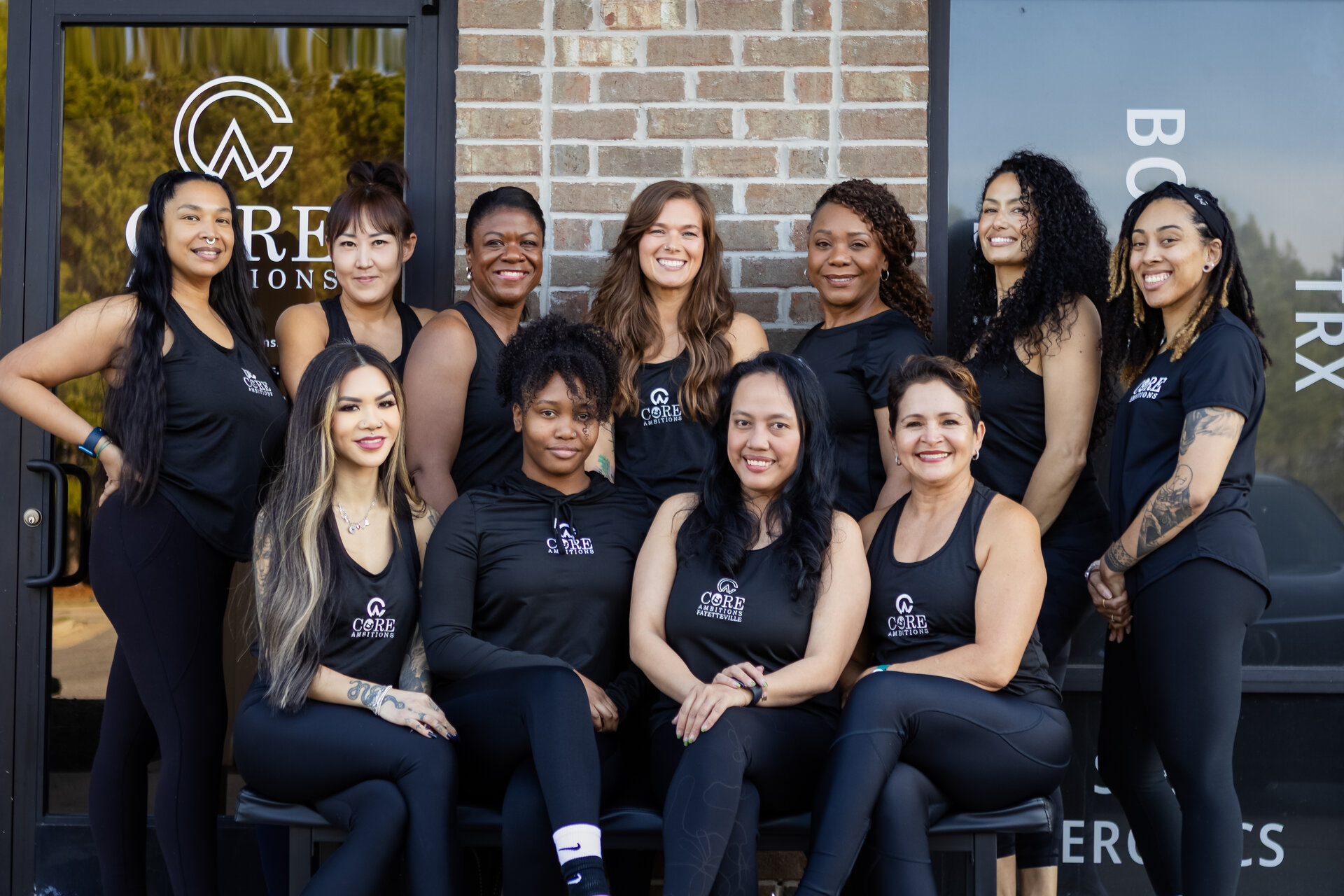 Core Ambitions team photo — instructors in branded clothing outside the studio